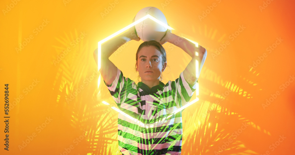 Caucasian female player throwing ball over illuminated plants and hexagon on orange background