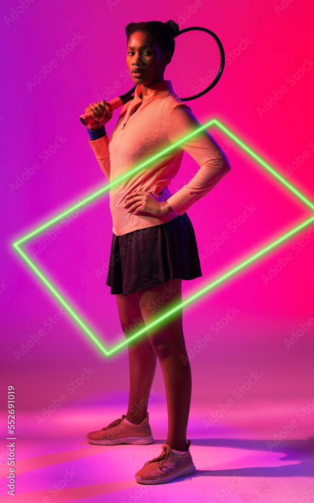 African american tennis player holding racket by illuminated rectangle on gradient background