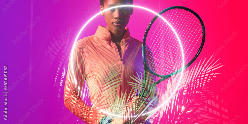 Midsection of african american female tennis player with racket by illuminated circle and plants