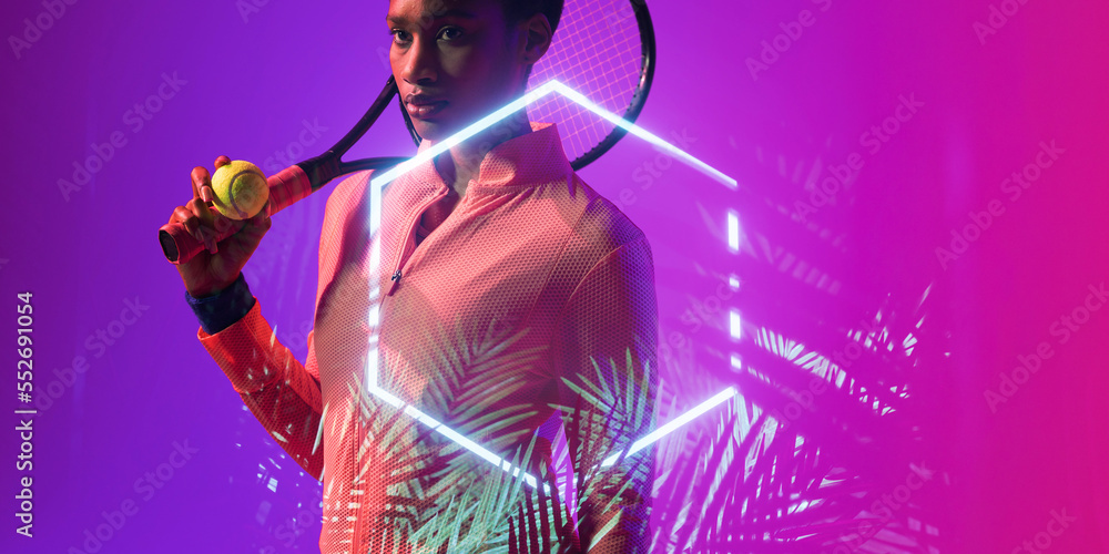 African american female tennis player holding ball and racket by illuminated hexagon and plants