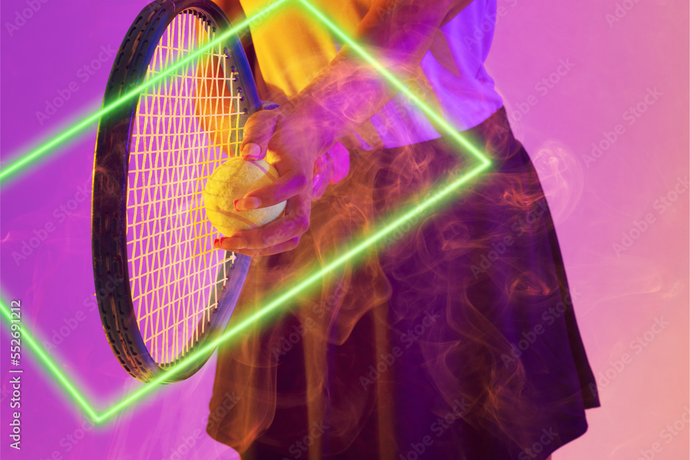 Midsection of african american female tennis player holding racket and ball by illuminated rectangle