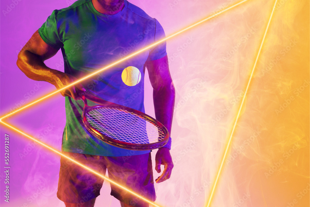 Midsection of african american male player bouncing ball with racket by illuminated triangle