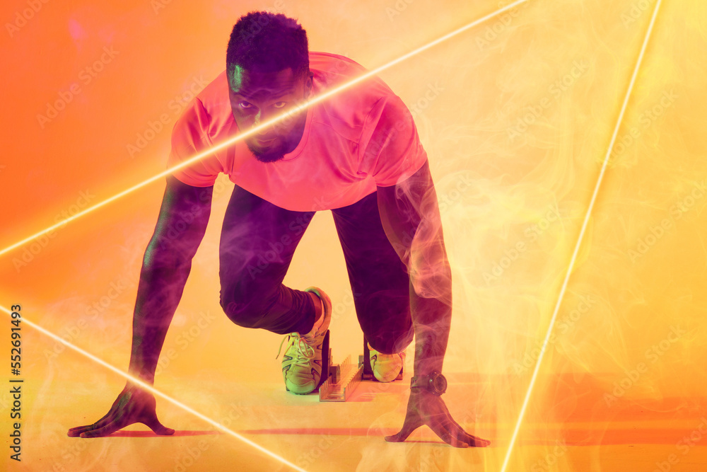 African american male athlete at starting position by illuminated triangle over gradient background