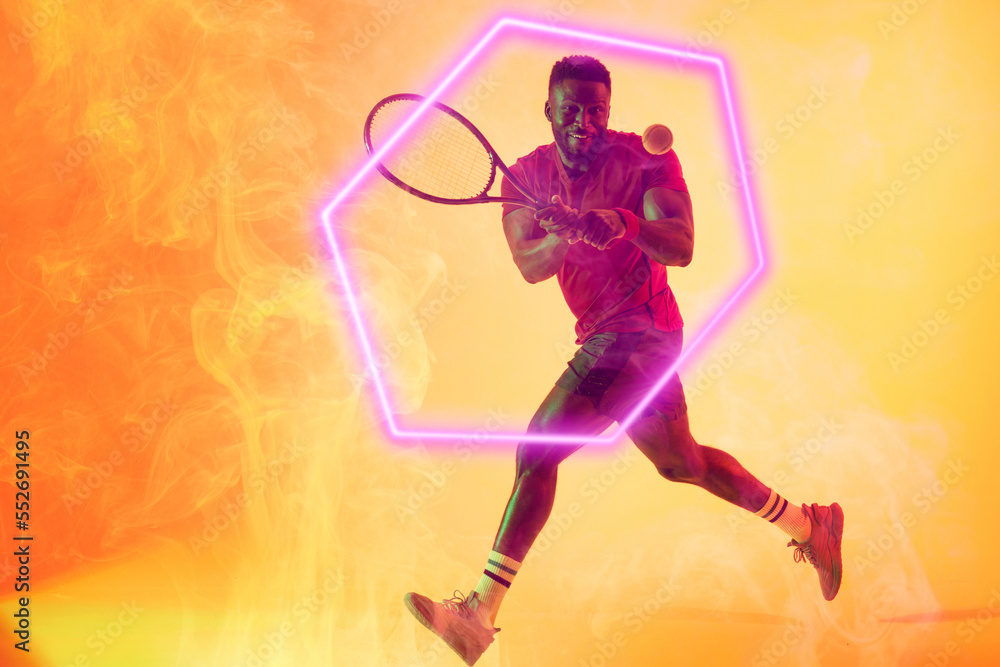 Illuminated hexagon over african american male player playing tennis with racket and ball