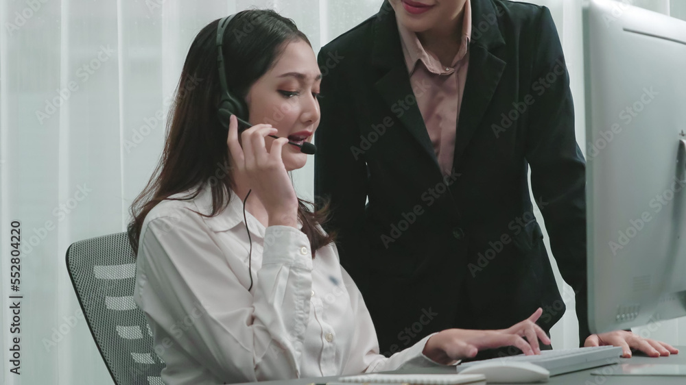 Enthusiastic asian female manager teaching new employee how to be productive customer service operat