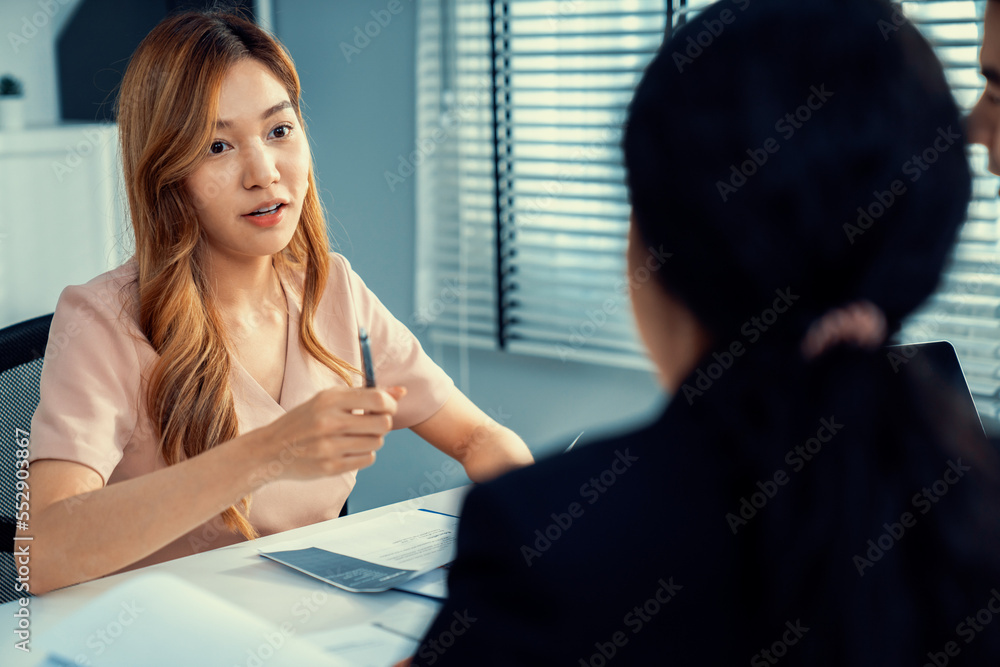 一位年轻的亚洲女性候选人试图通过自己的能力给面试官留下深刻印象。国际合作