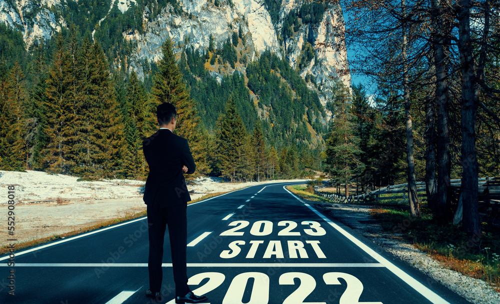 The 2023 New Year journey and future vision concept . Businessman traveling on highway road leading 