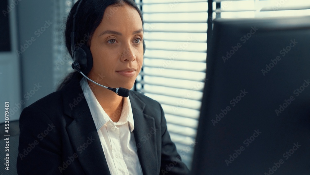 Competent female operator working on computer and talking with clients. Concept relevant to both cal