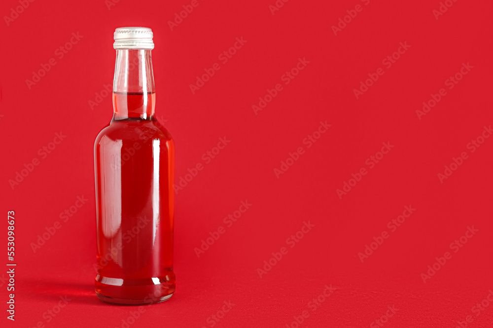 Bottle of tasty drink on color background