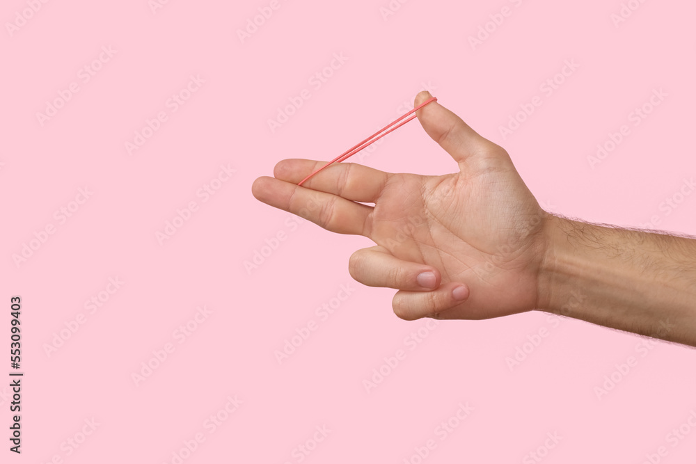 Man with red rubber band on pink background