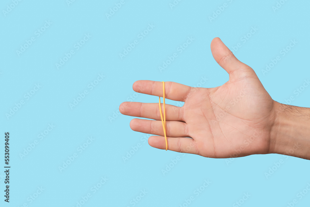 Man with yellow rubber band on blue background