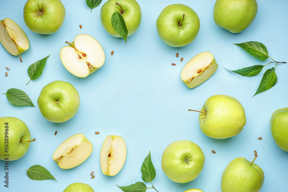 Frame made of whole and cut green apples on color background