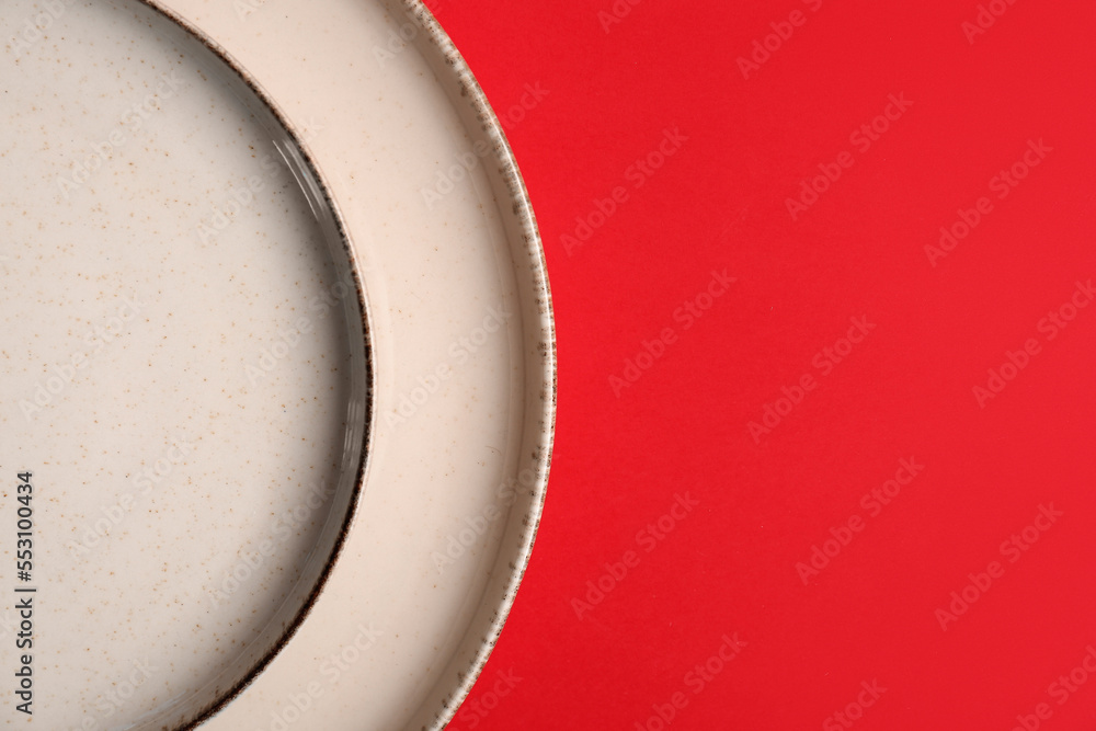 Beautiful plates on red background, closeup