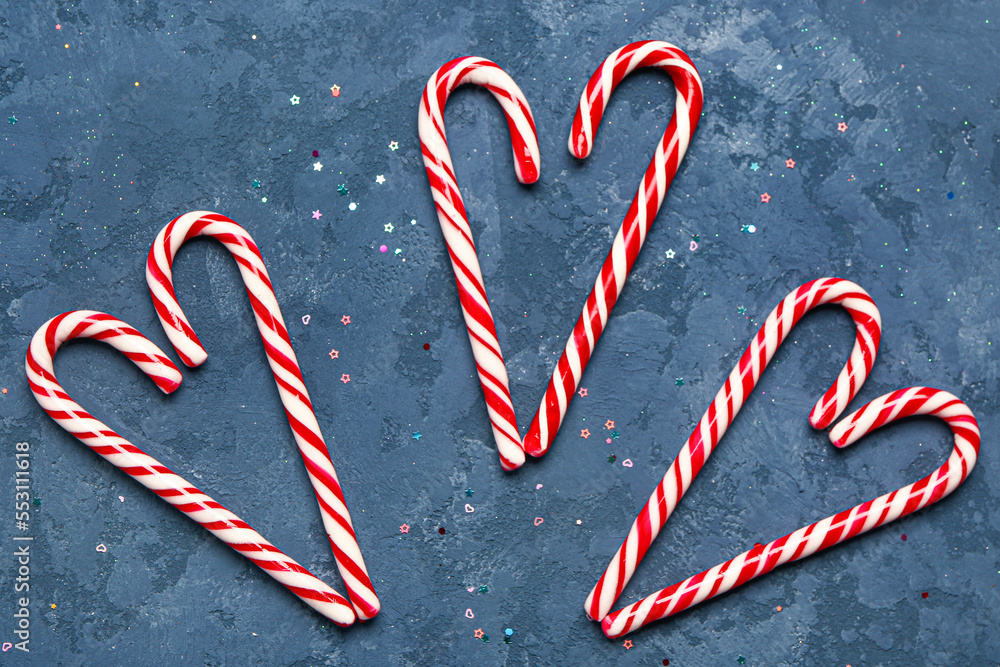 Hearts made of sweet candy canes on color background