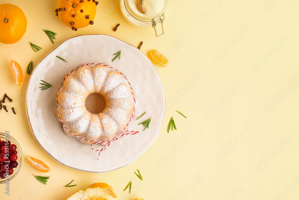 Composition with plate of tasty Christmas cake and tangerines on yellow background