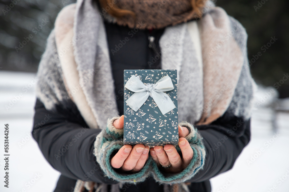 woman holding Christmas decoration in snow