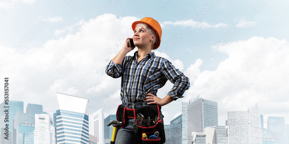 Attractive woman in workwear and hardhat