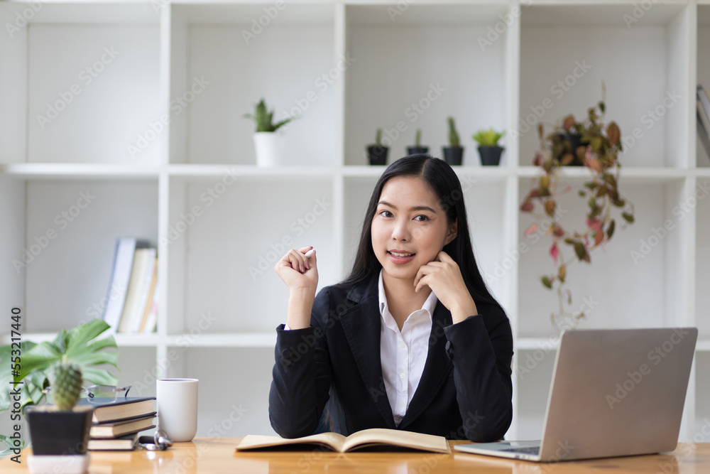 美丽的亚洲女商人在办公室里用笔记本电脑工作的肖像。