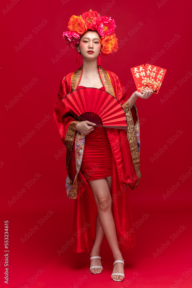 亚洲年轻女性的全身照，穿着时尚的现代qipao-cheonam连衣裙微笑着，飘逸着