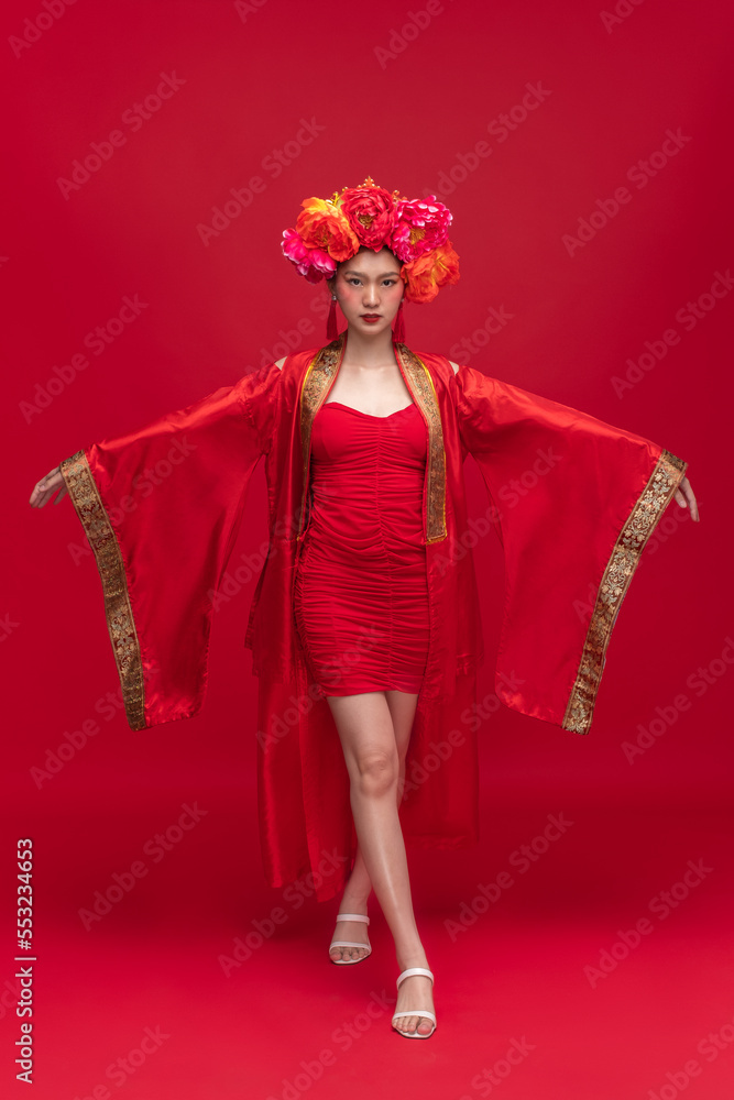 Full body portrait of young asian woman wearing fashion modern qipao cheongsam dress smile and flowe