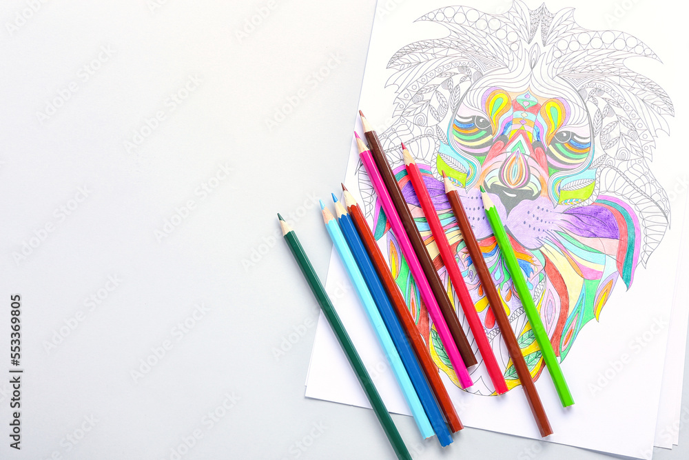 Coloring page and pencils on light background