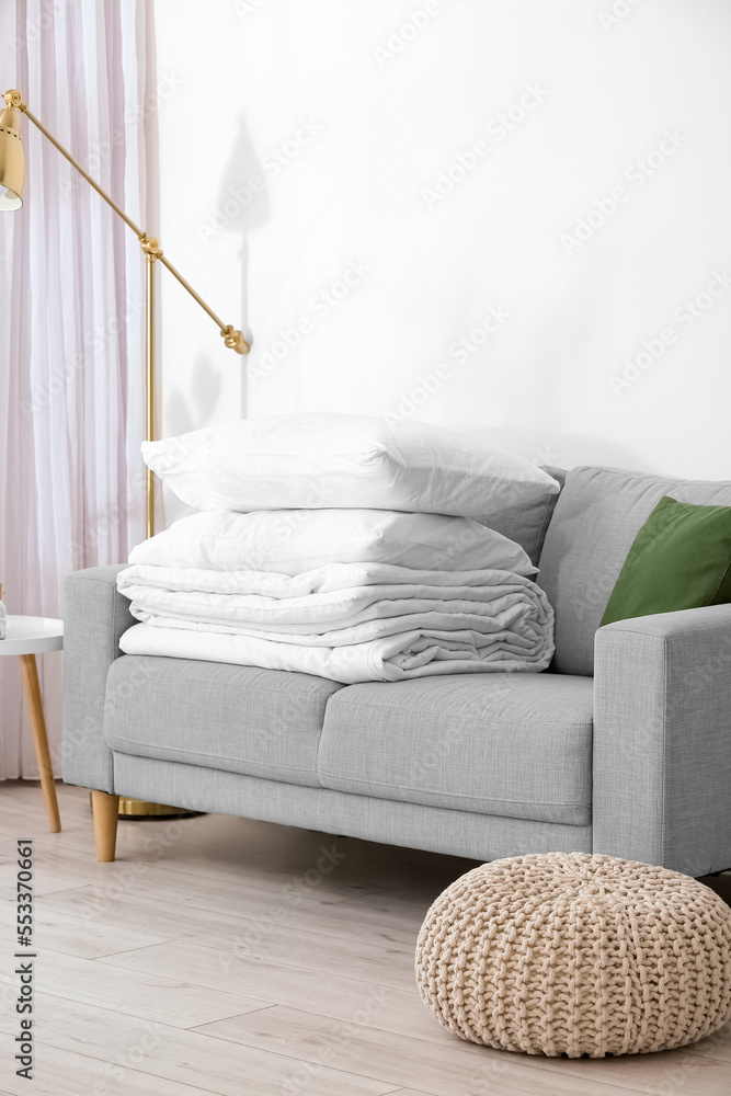 Folded blanket and pillows on sofa in room