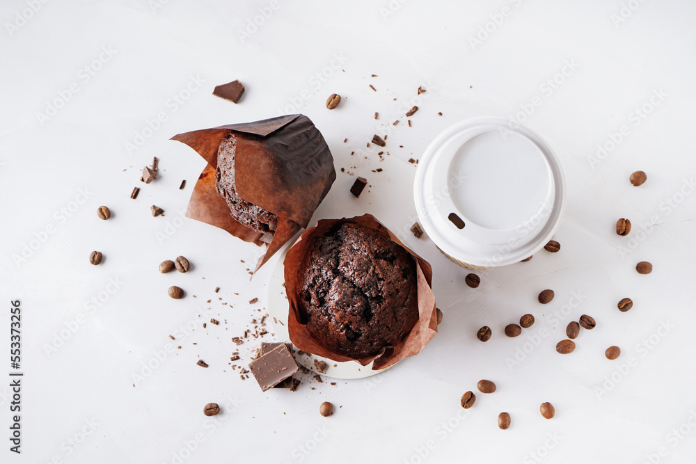 Tasty chocolate muffins and cup of coffee on light background