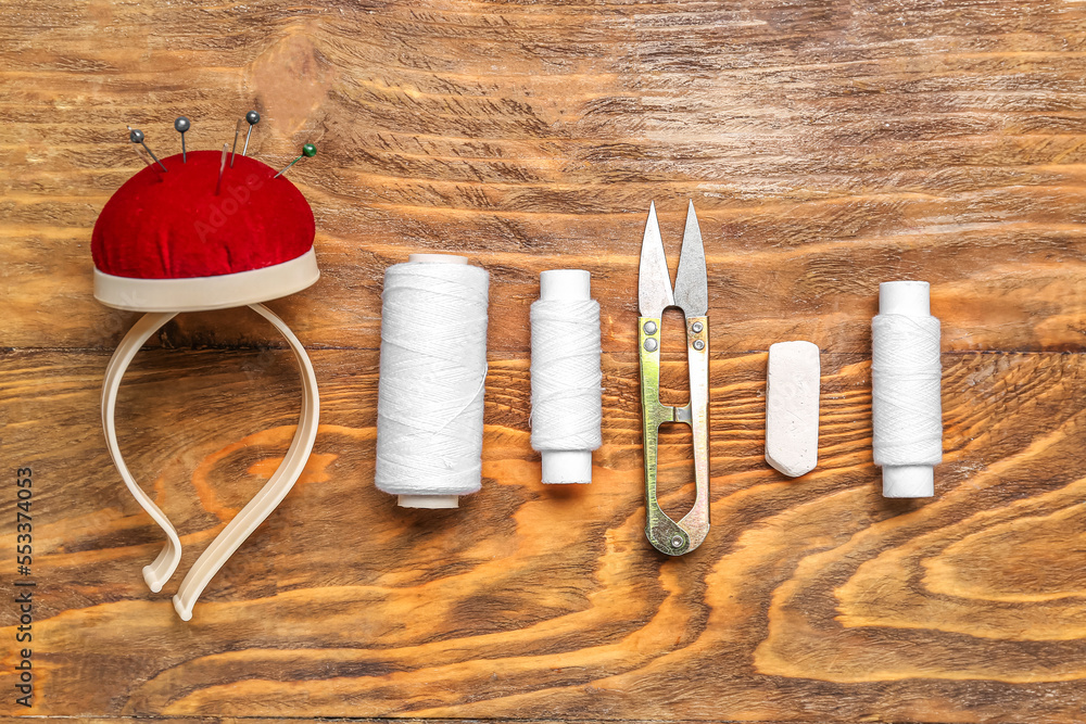 Set of sewing supplies on wooden background