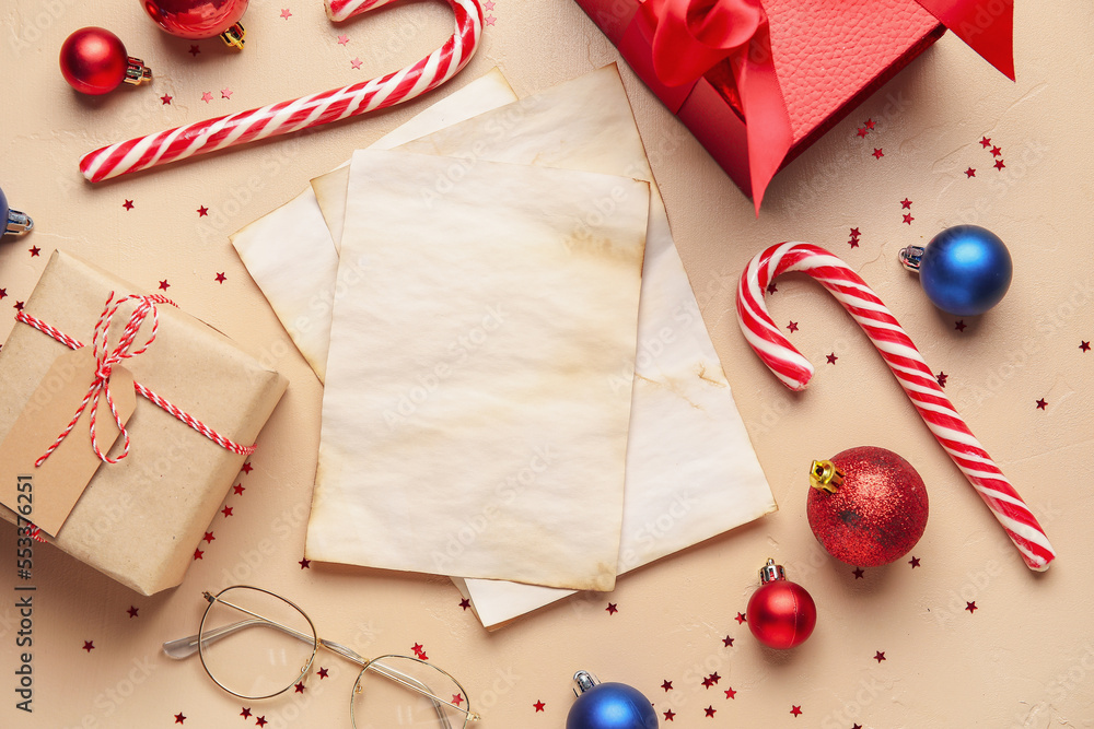 Blank letters to Santa with Christmas decor, eyeglasses and gifts on beige background