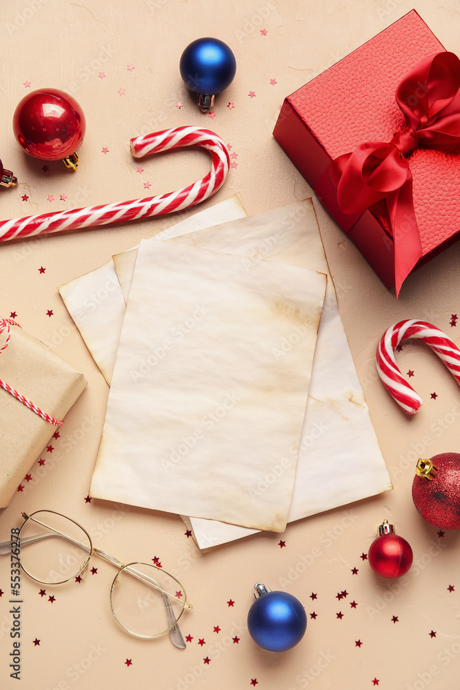 Blank letters to Santa with Christmas decor, eyeglasses and gifts on beige background