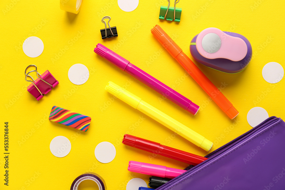 Composition with pencil case and different stationery on yellow background, closeup