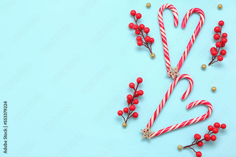 Composition with sweet candy canes and Christmas decor on color background