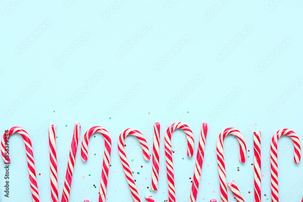 Composition with delicious candy canes on color background