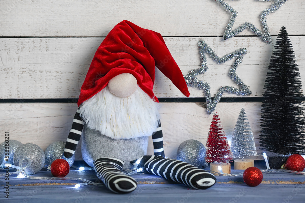 Funny Christmas gnome and decorations on wooden table