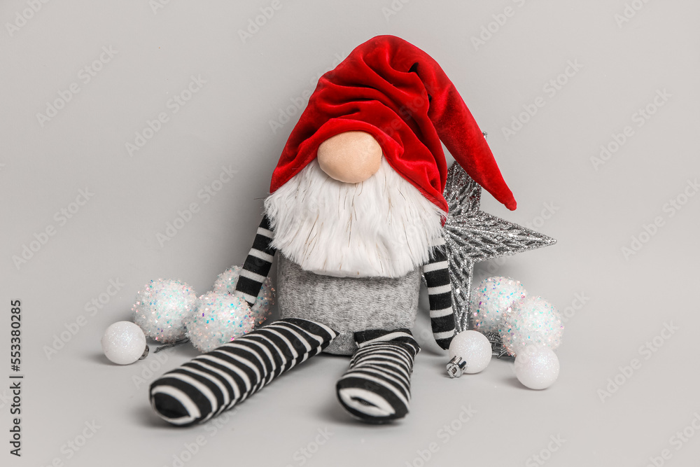 Funny Christmas gnome and decorations on grey background