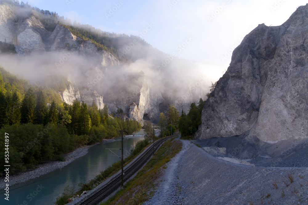 Cliff with cone of debris at canyon of Anterior Rhine Valley on a blue cloudy autumn morning at Vers