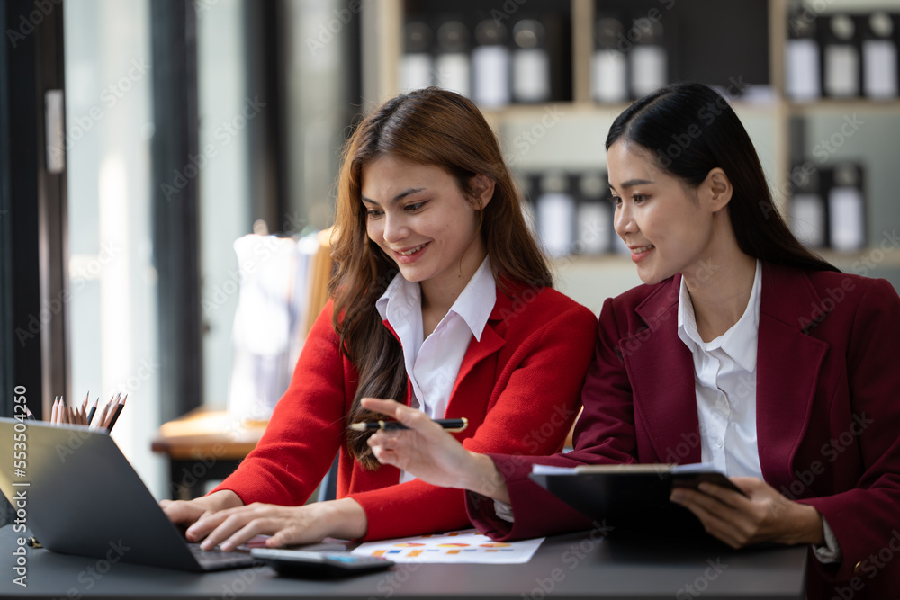 Two beautiful asian business female colleagues interacting while working in office, Business partner