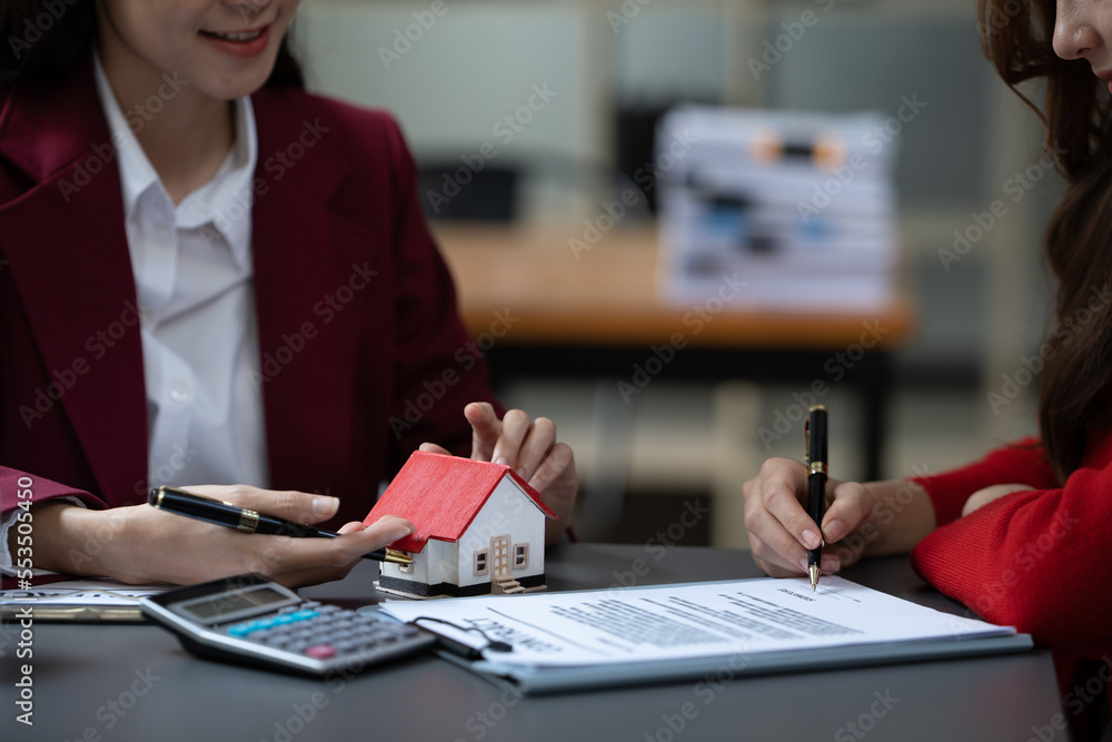 亚洲女商人达成协议，在办公室内购买房屋或公寓，家庭保险概念