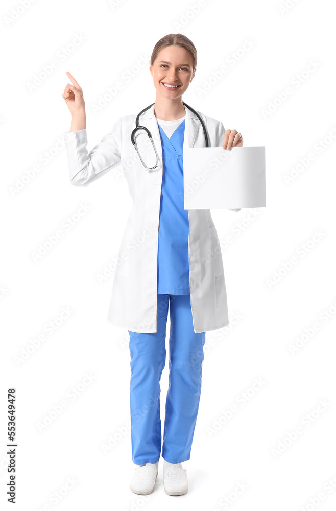 Female doctor with blank paper sheet pointing at something on white background