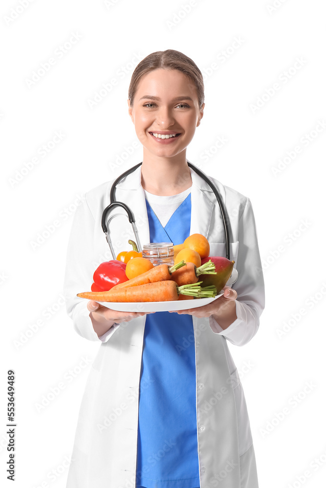 Female doctor with plate of vegetables on white background