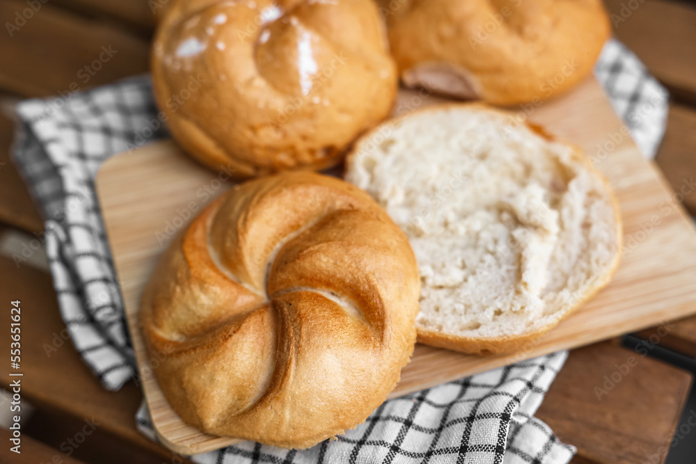 Delicious kaiser rolls on wooden board