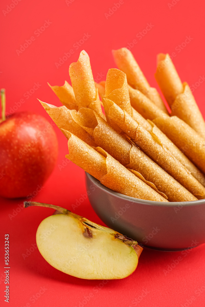 Bowl of tasty apple pastilles on red background, closeup