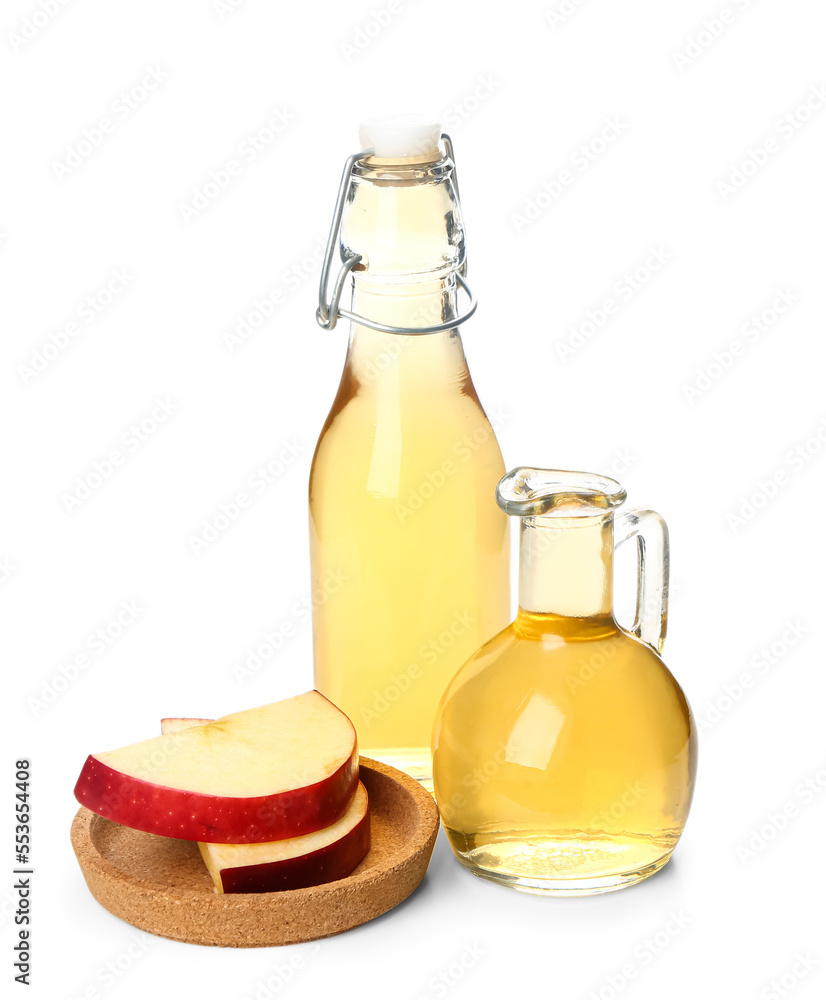 Bottle and jug of apple cider vinegar on white background