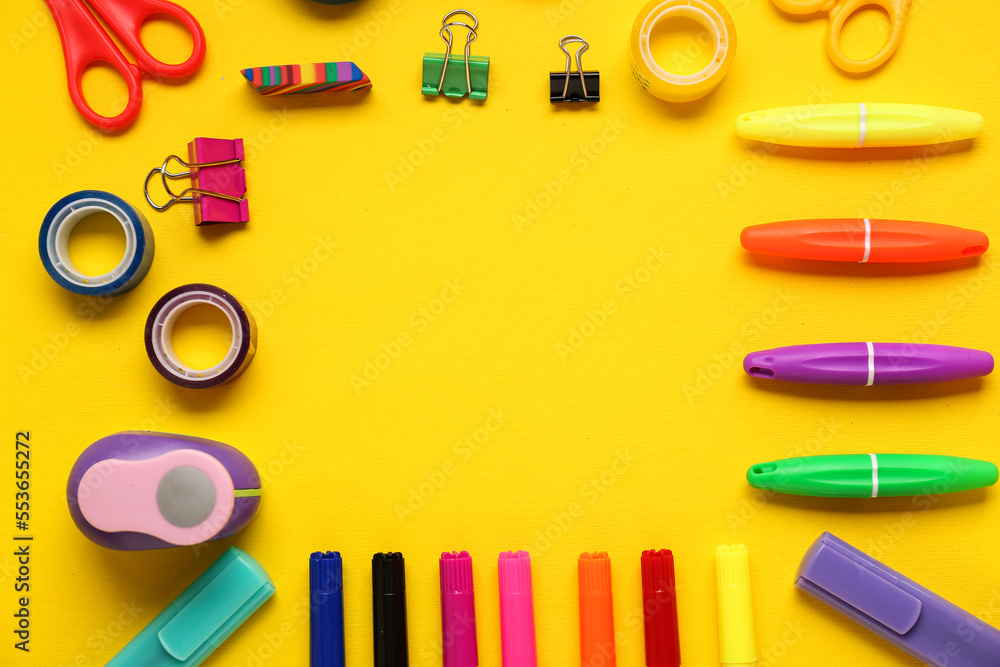 Frame made of different stationery on yellow background