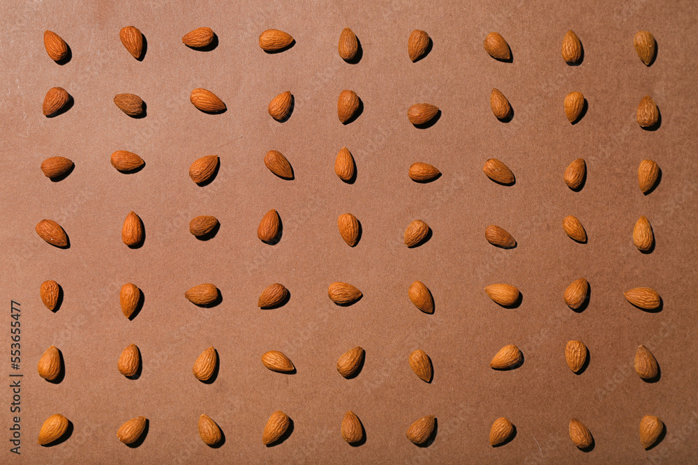 Many almonds on brown background