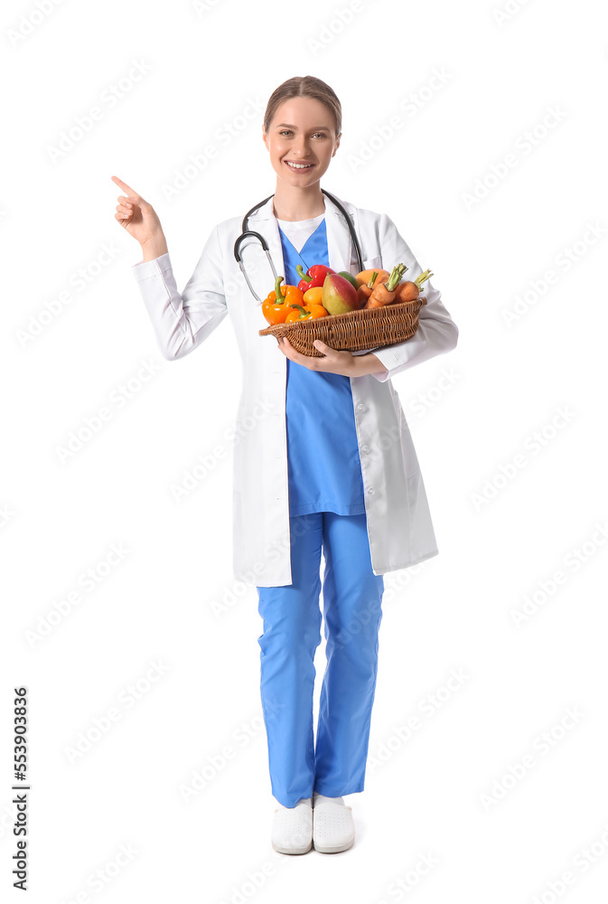 Female doctor with healthy food pointing at something on white background