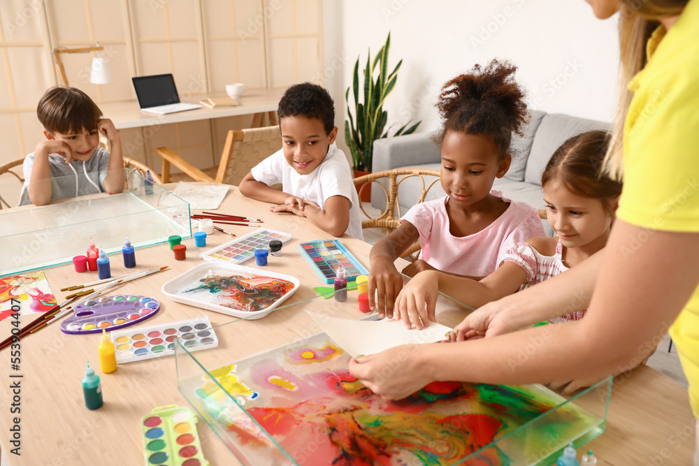 Little children with teacher marbling paper in workshop for Ebru painting