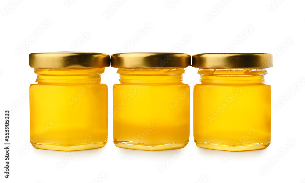 Jars with delicious honey on white background