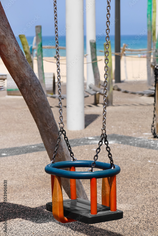 View of childrens swing on playground near sea, closeup