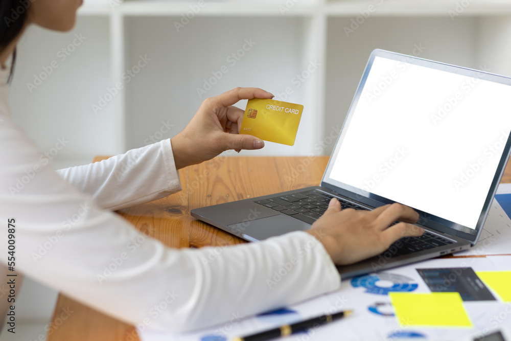 Woman holding credit card using laptop. Online payment and online shopping concept.